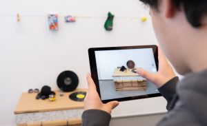 Kind arbeitet an iPad an Kunstobjekt